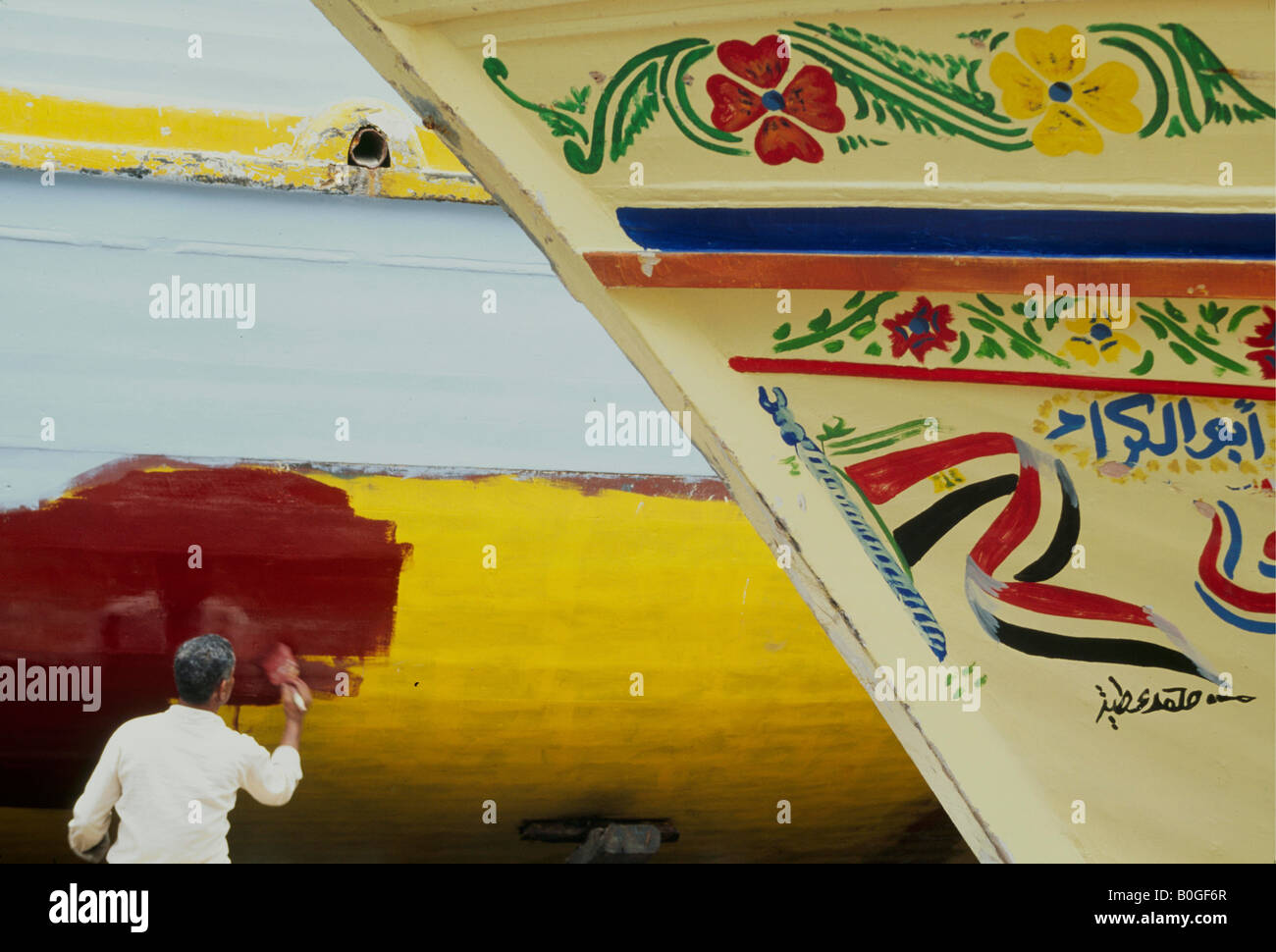 Un homme la peinture de la coque d'un bateau, Le Caire, Égypte. Banque D'Images