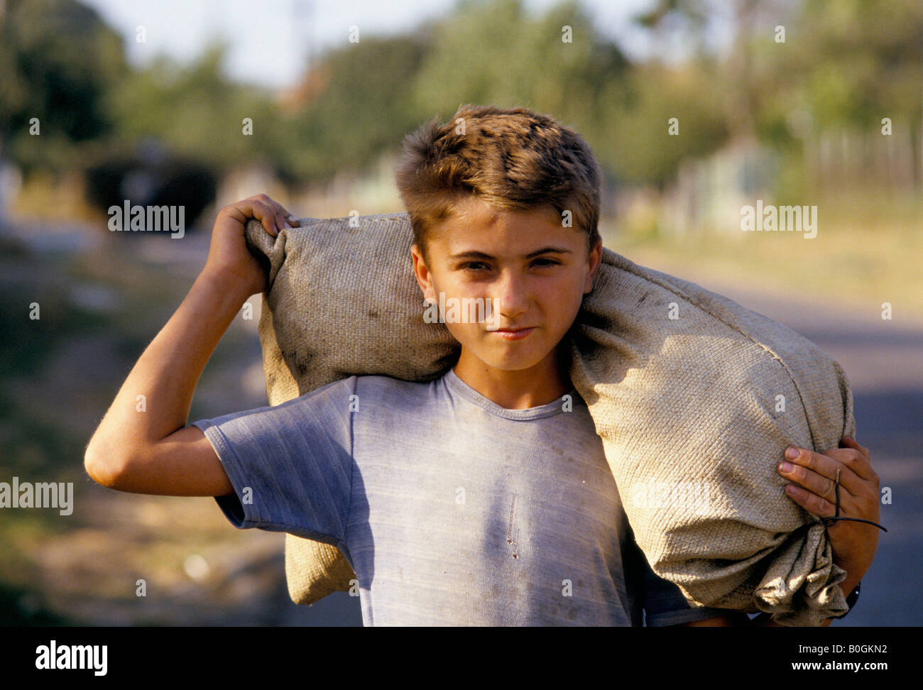 Un garçon portant un sac sur ses épaules, la Roumanie. Banque D'Images