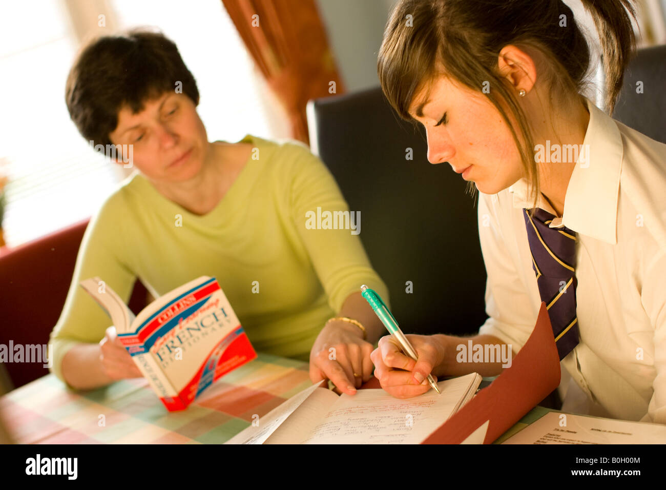 Mère d'aider sa fille à faire ses devoirs Banque D'Images