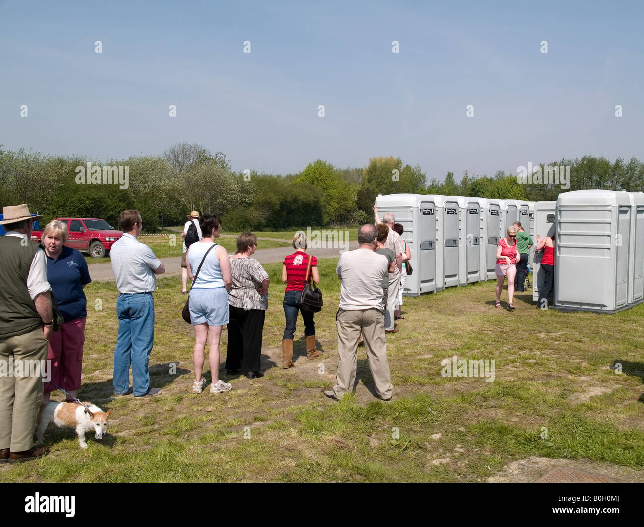 Les gens faisant la queue pour utiliser les toilettes temporaires à un country fair Banque D'Images