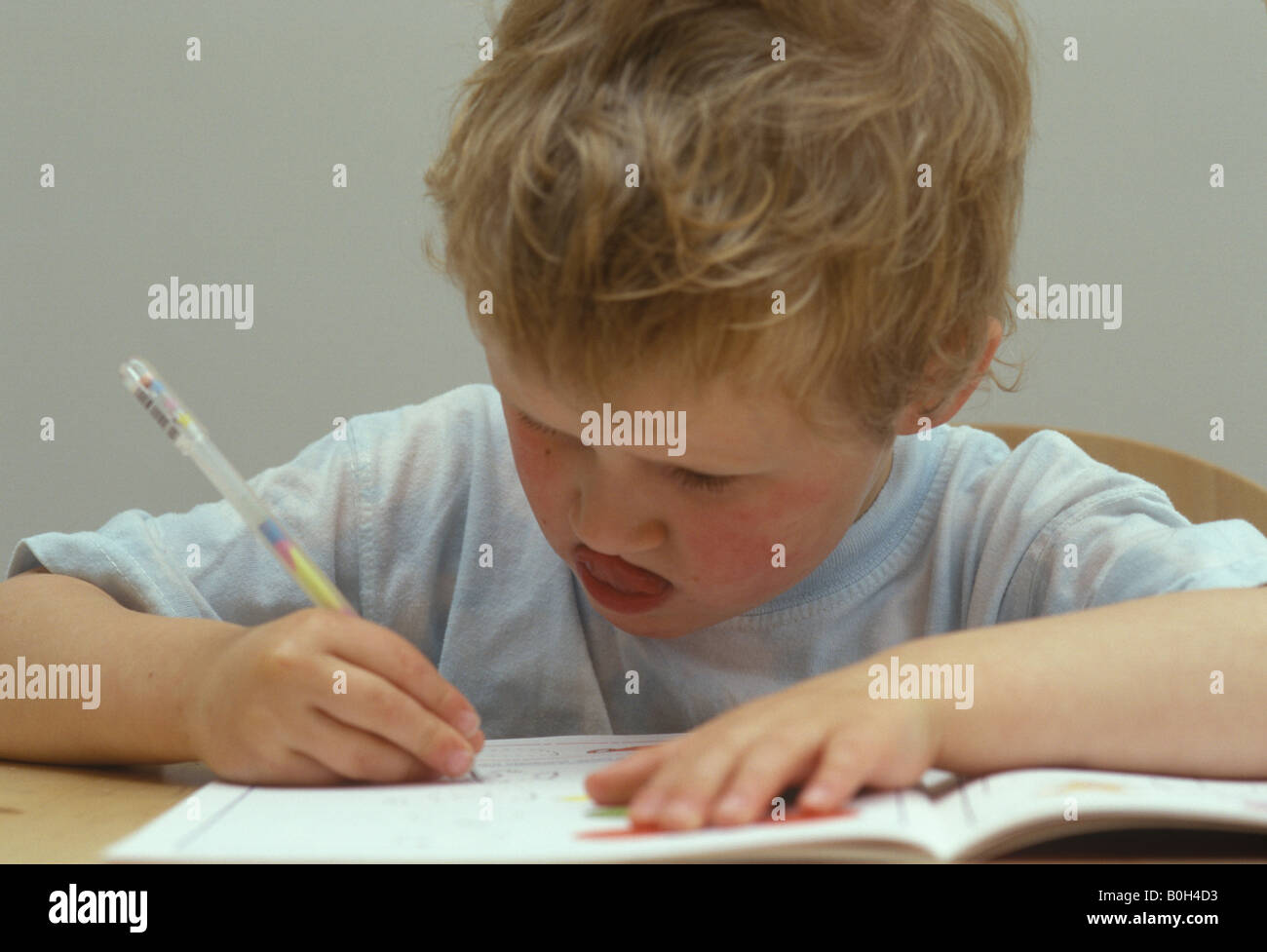 Garçon se concentrant sur ses lettres de dessin Banque D'Images