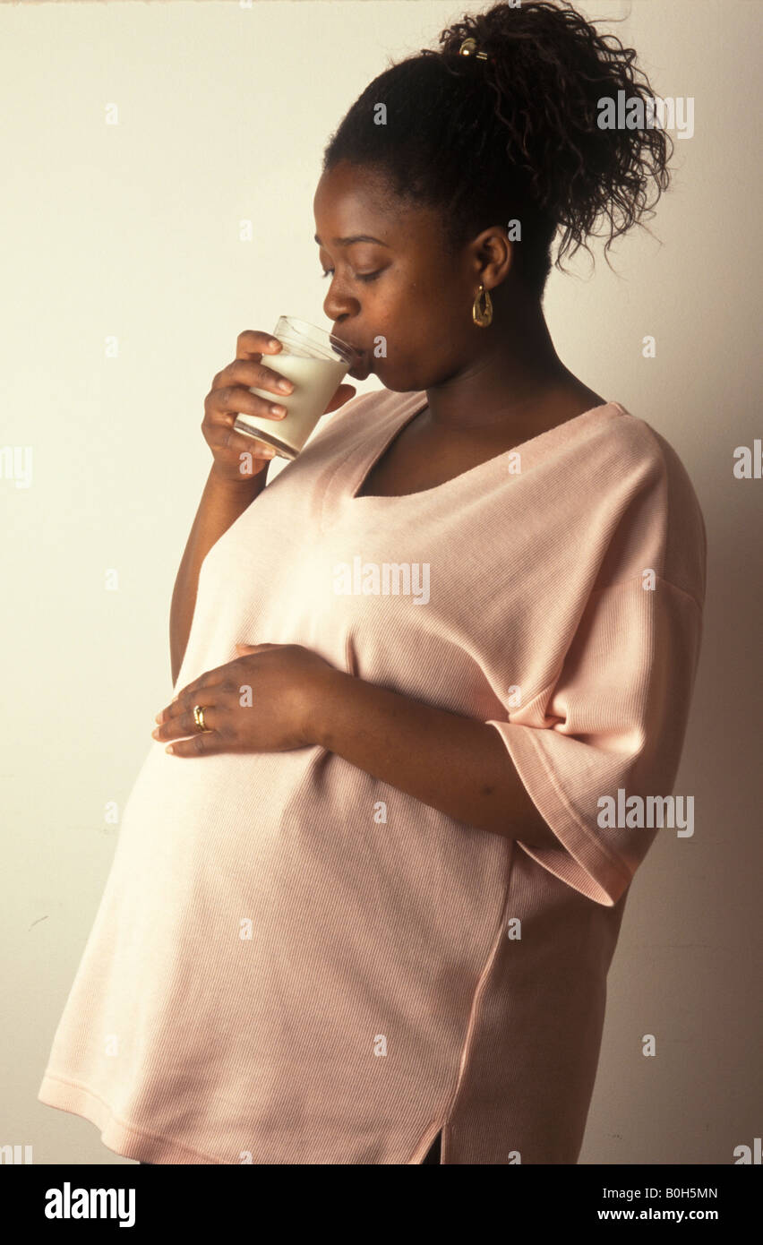 Ethnique enceinte femme à boire un verre de lait Banque D'Images