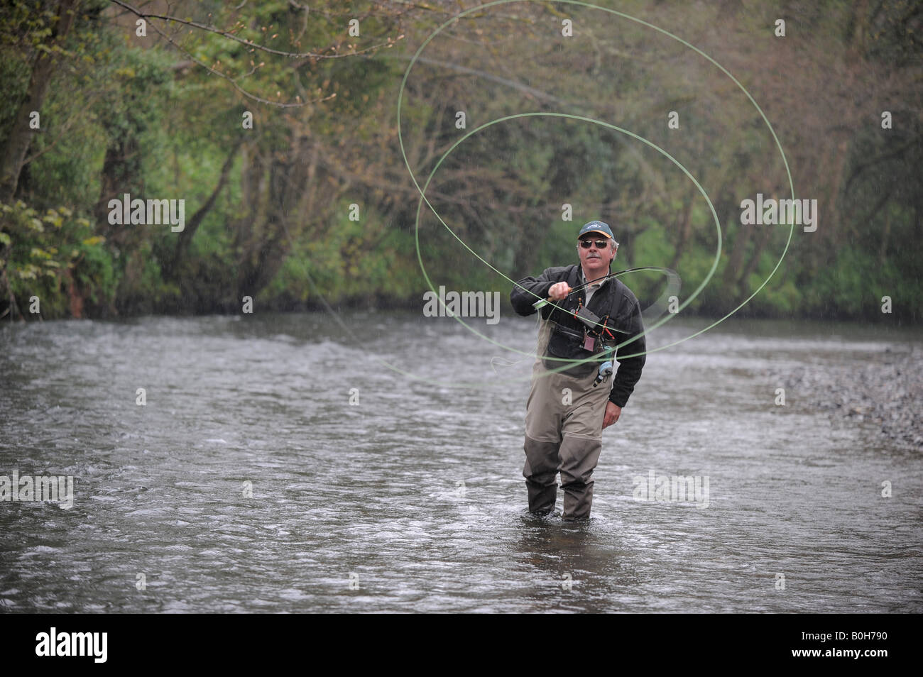 Gary Champion, la pêche à la mouche sur la rivière, Lyd Lifton, Devon. Gary chasser avec la ligne de pêche dans une bobine forme. Banque D'Images
