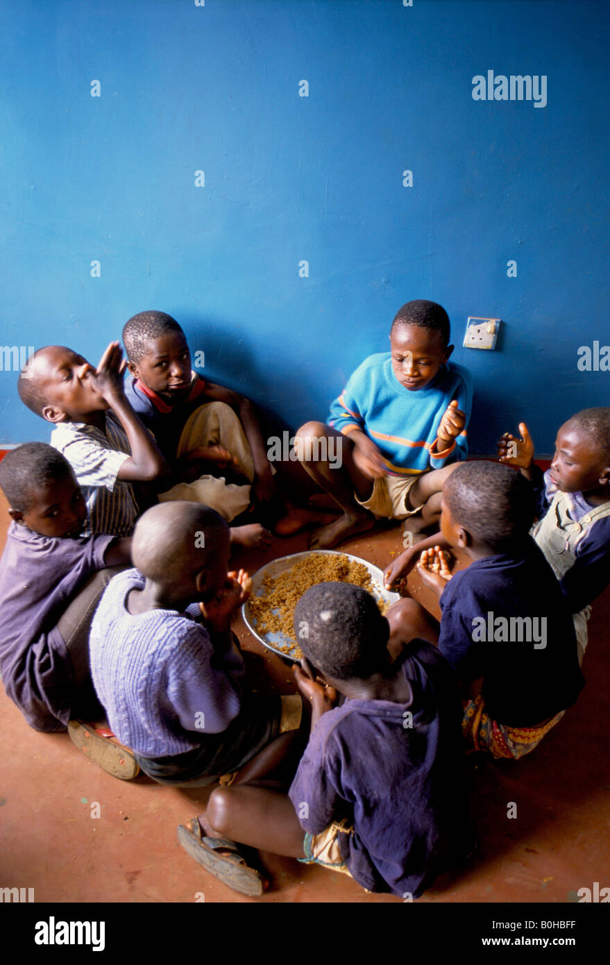 Les enfants des rues de manger des aliments fournis par un refuge, en Tanzanie. Banque D'Images