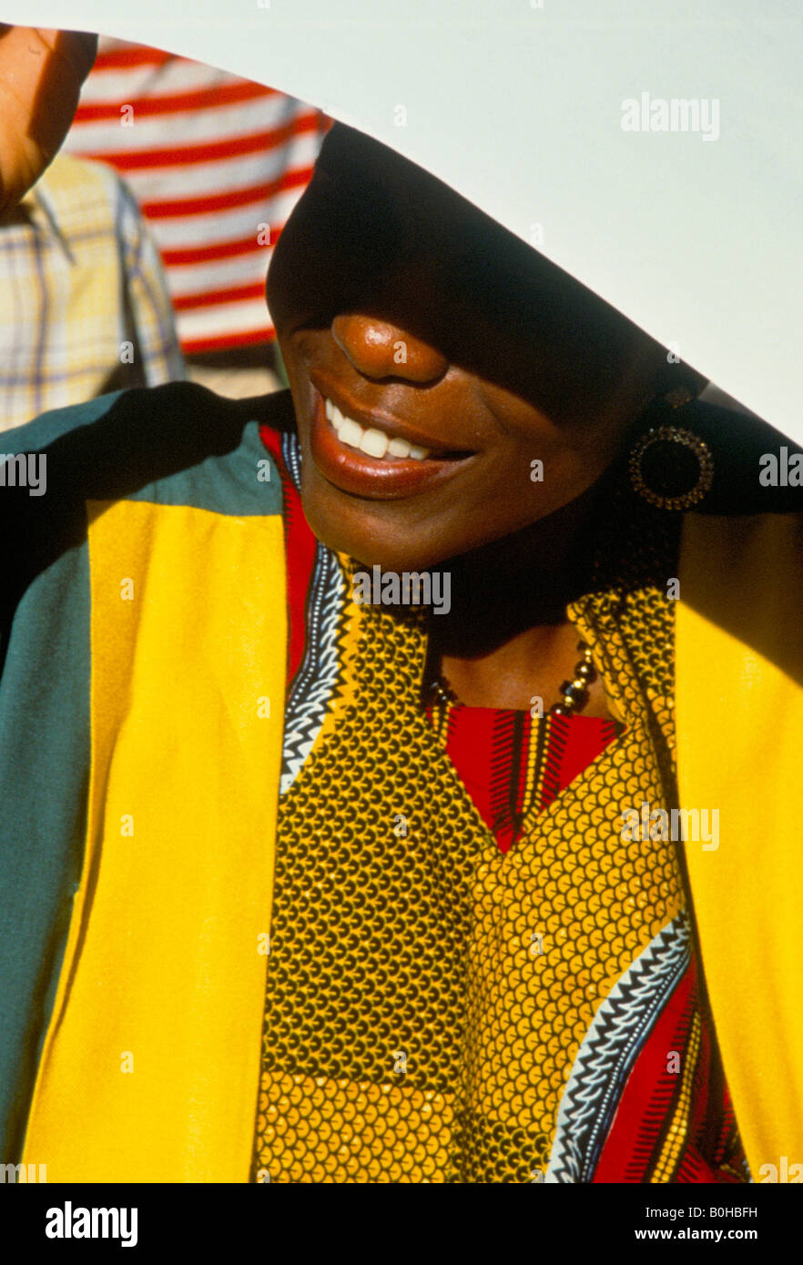 Une femme se protège du soleil avec un morceau de papier, en Tanzanie. Banque D'Images