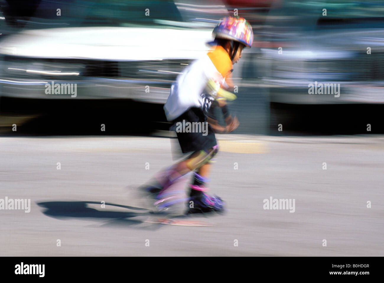 Un enfant roller cours des voitures stationnées dans Harlem, New York City, New York, USA. Banque D'Images