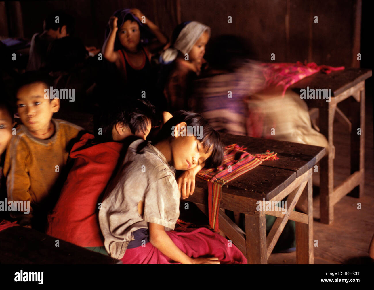 Les enfants endormis à leur bureau dans l'école après avoir travaillé dans les champs, Kalaw, le Myanmar. Banque D'Images