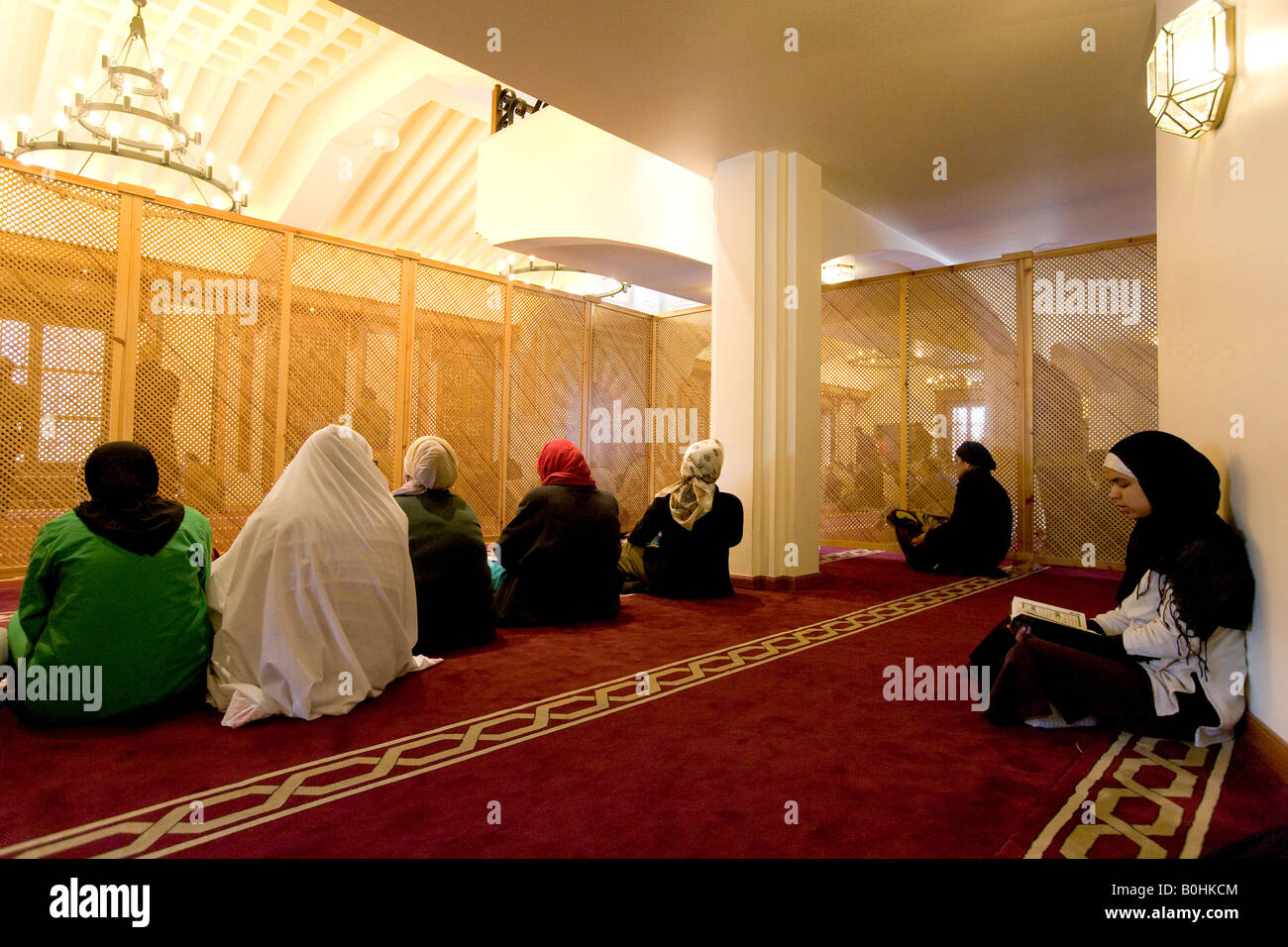 Les femmes derrière un écran lors de la prière du vendredi à la Grande Mosquée de Cordoue, assis jambes croisées sur un tapis rouge de l'El Albay Banque D'Images