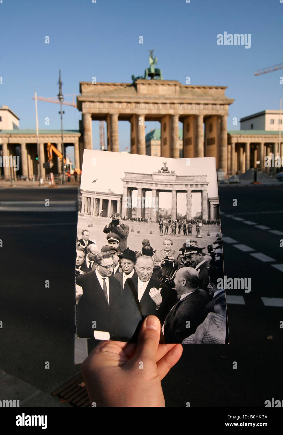 Hier et aujourd'hui, main tenant une photo en noir et blanc de Konrad Adenauer devant la Brandenburger Tor ou Porte de Brandebourg, être Banque D'Images