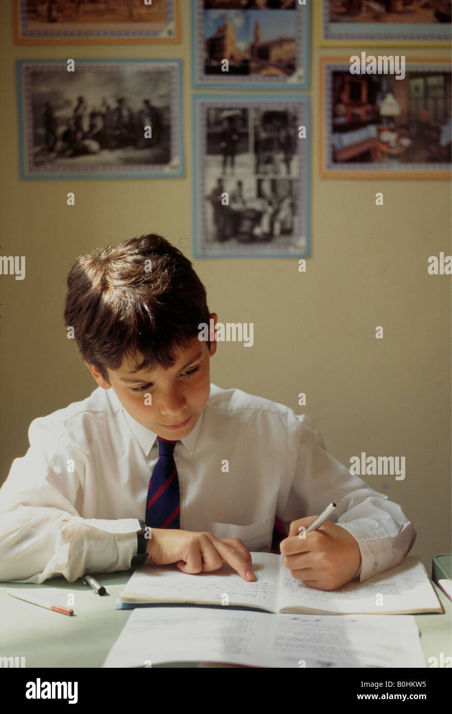 Un enfant écrit en classe à l'École Junior de Highgate, Londres, Angleterre. Banque D'Images