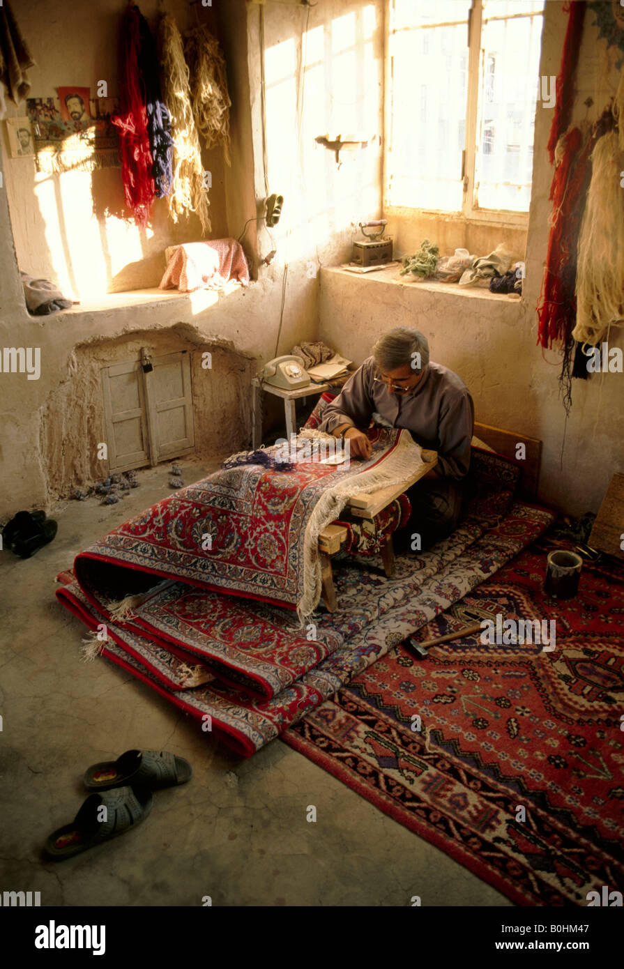 Un homme part dans un atelier de couture de tapis, Ispahan, Iran. Banque D'Images