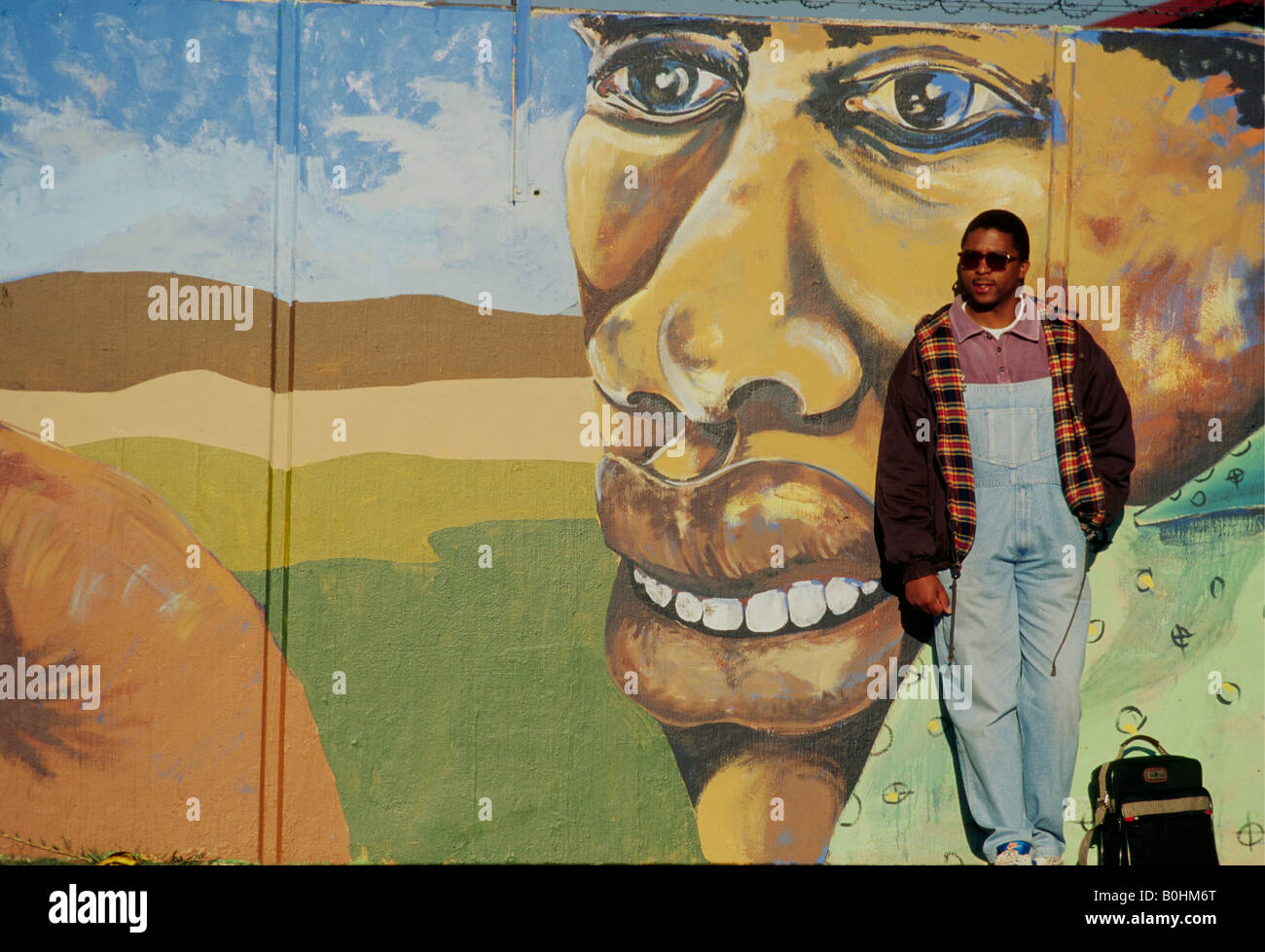Un homme debout en face d'une peinture murale, Afrique du Sud. Banque D'Images
