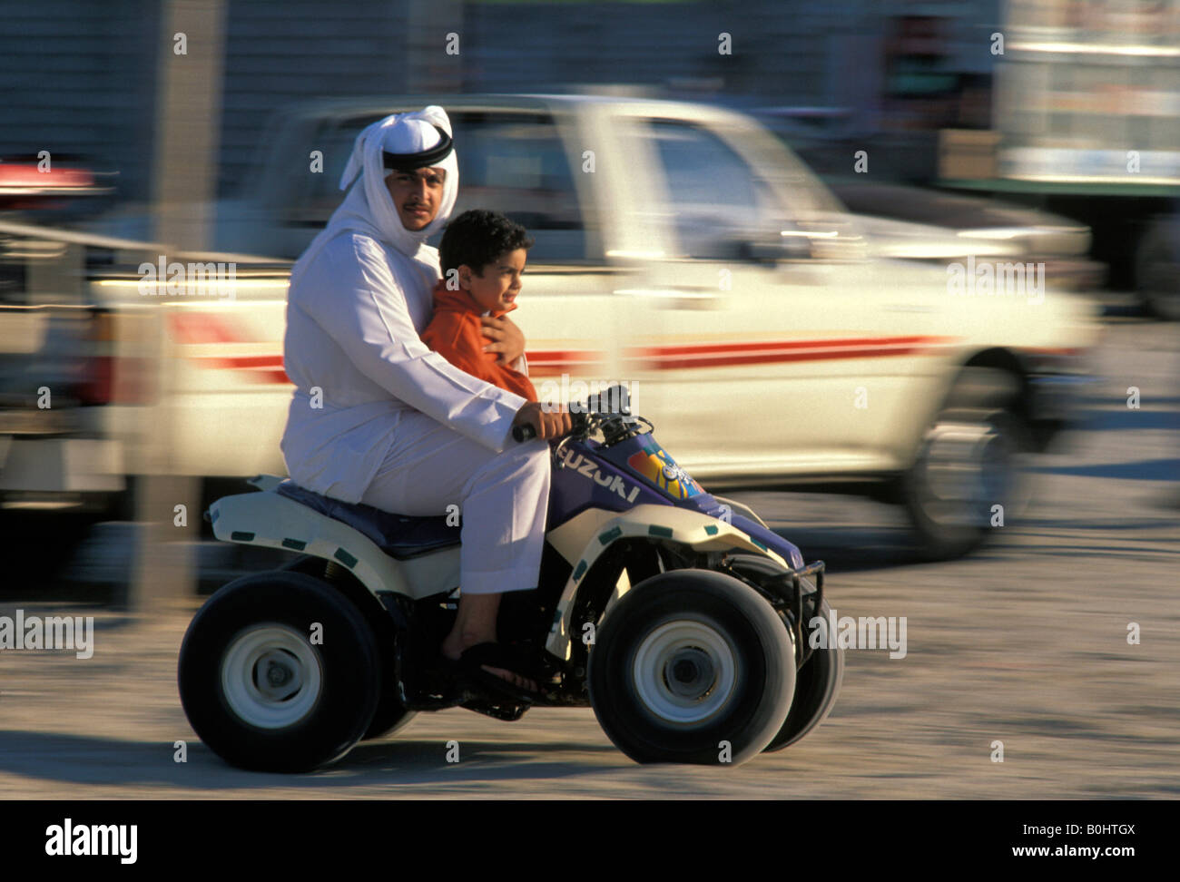 Un homme et enfant sur un quad, l'Arabie Saoudite. Banque D'Images