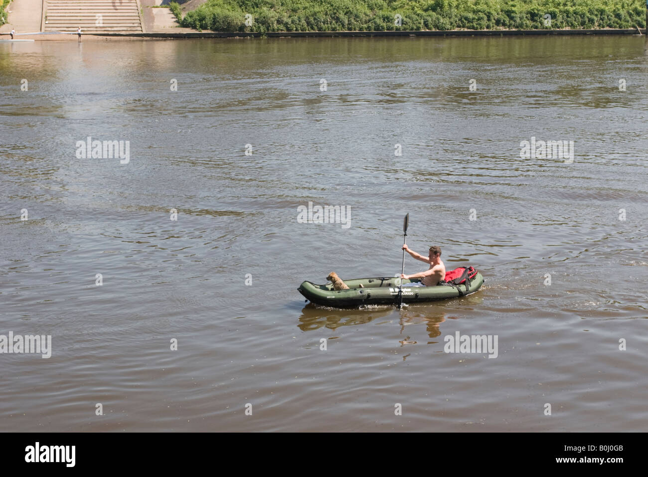 L'homme en canoë gonflable palettes de Chiswick Bridge pendant que le chien est assis à l'avant Banque D'Images