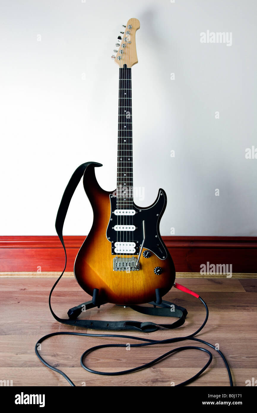 Photo couleur vertical d'une guitare électrique avec câble de puissance et sangle de cuir Banque D'Images