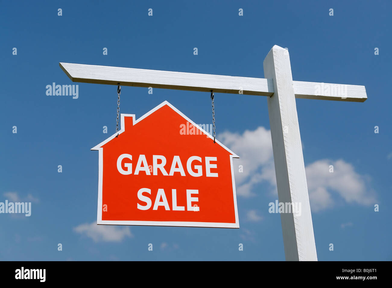 Post en bois blanc avec vente de garage rouge avis sur ciel bleu Banque D'Images