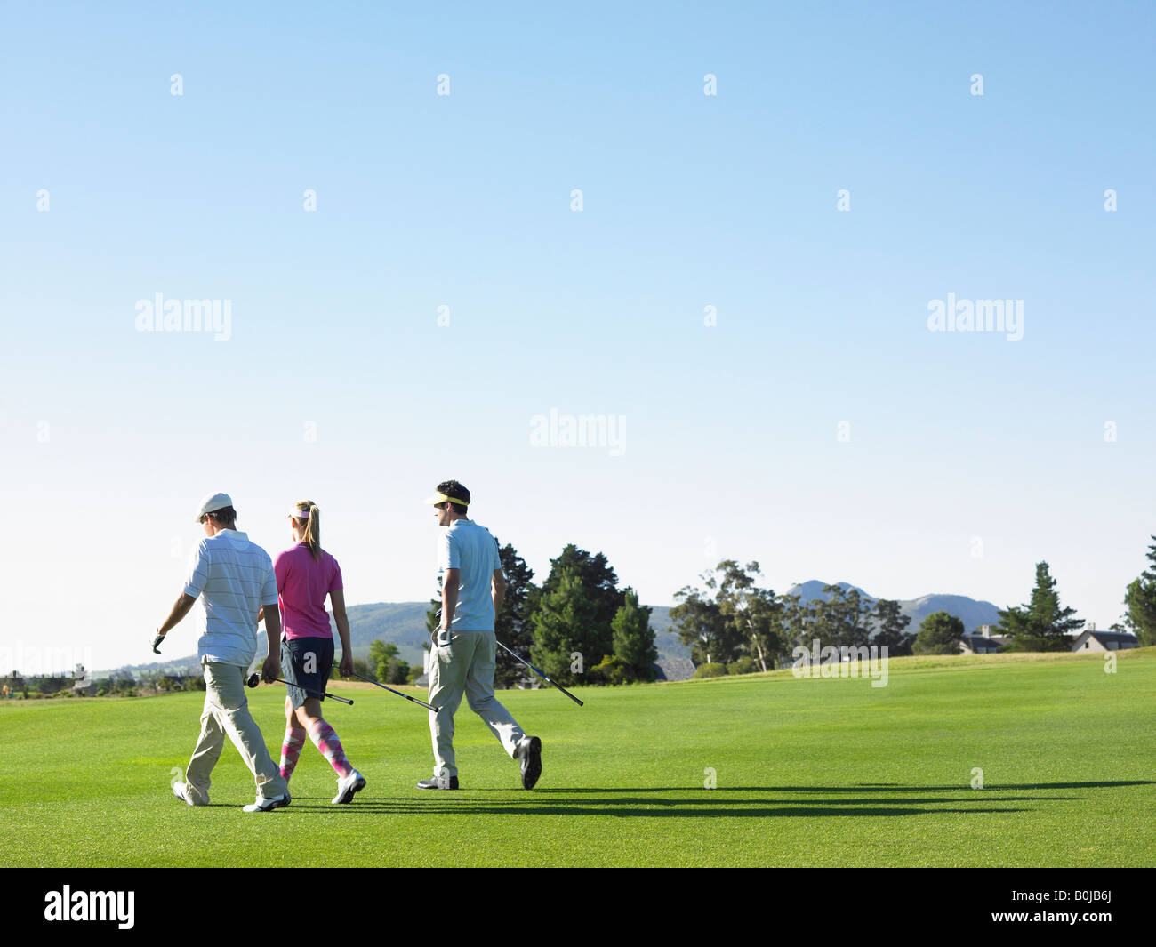 Trois golfeurs sur le cours Banque D'Images