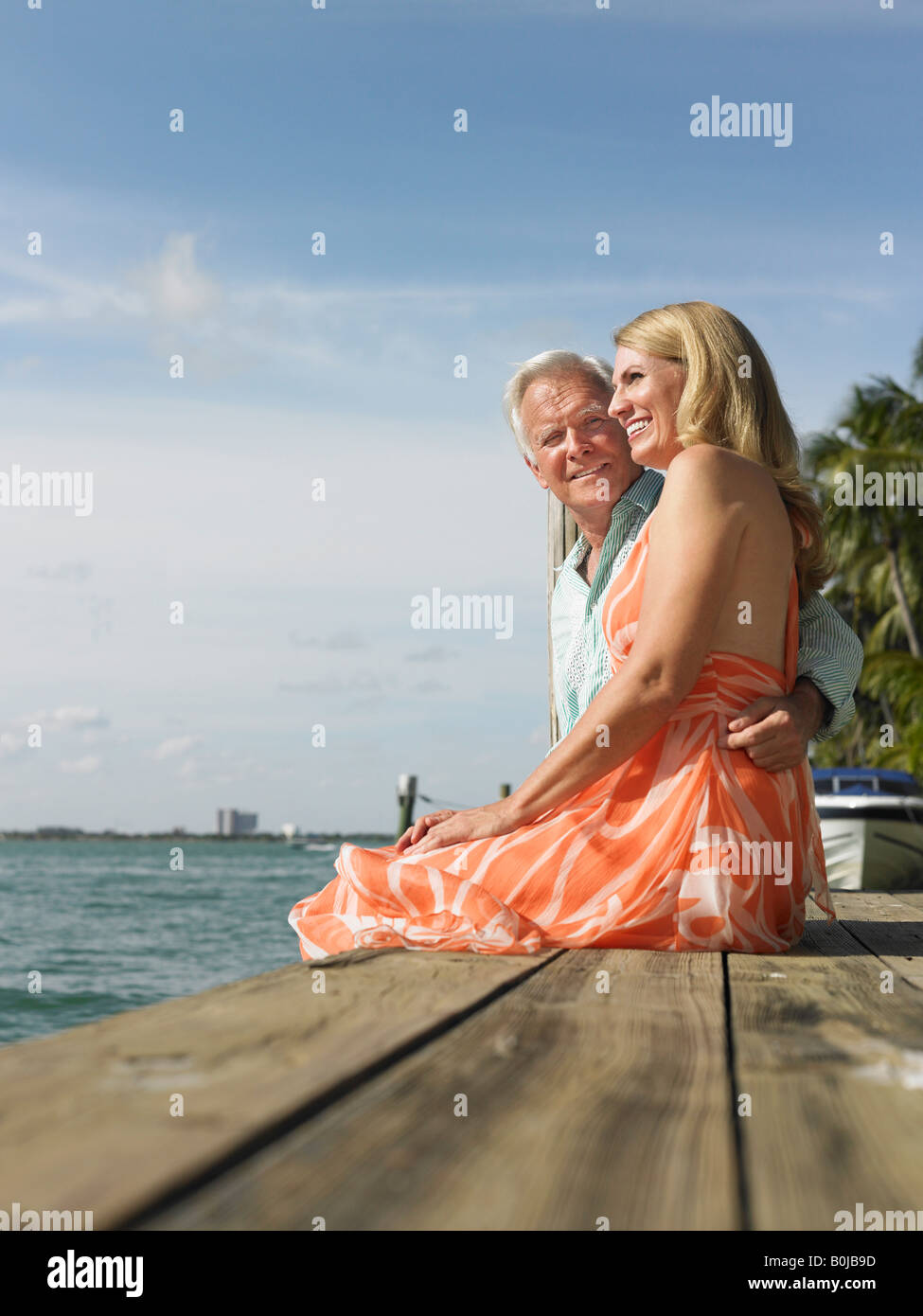 Couple assis sur le bord de la jetée, side view Banque D'Images