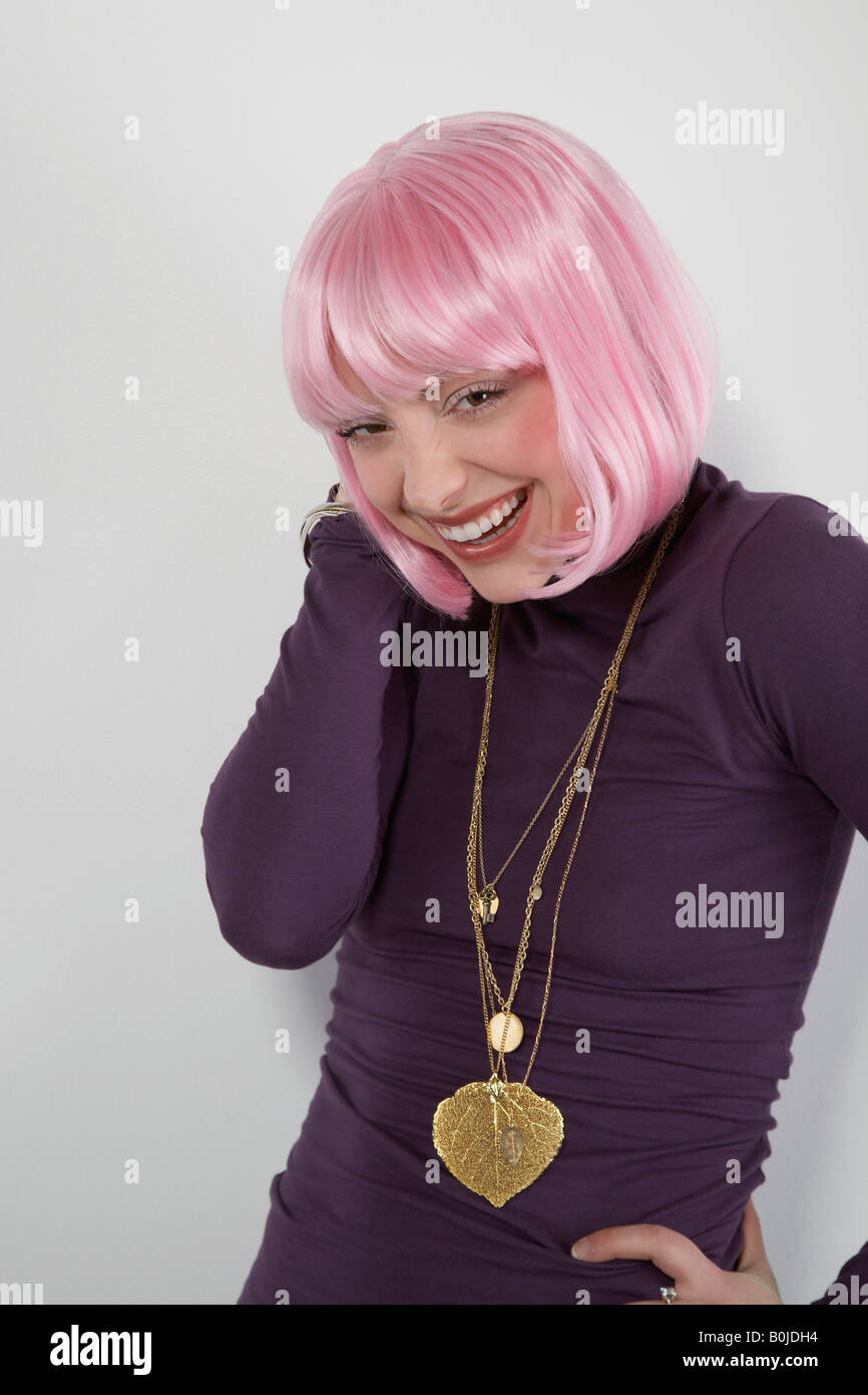 Jeune femme portant perruque rose, rire, portrait Banque D'Images