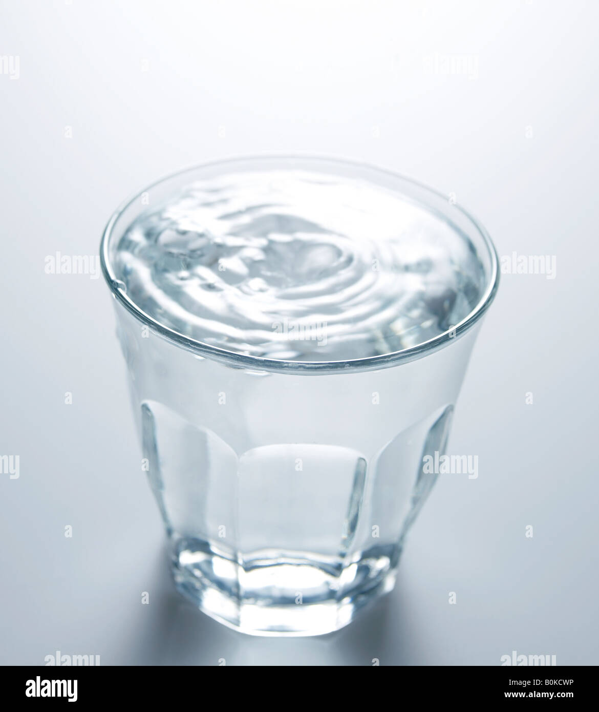 Gouttes d'eau tomber sur verre plein d'eau Photo Stock - Alamy