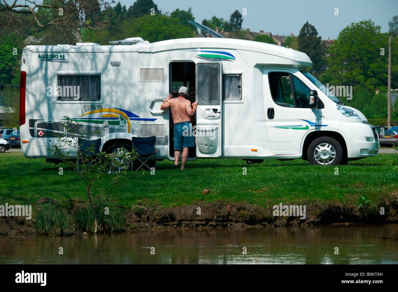 Camping-car moderne avec l'homme debout à l'extérieur garée à côté du fleuve dans le Derbyshire, Angleterre Banque D'Images