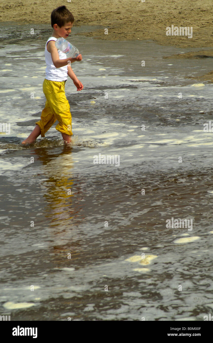 Un Enfant à Leau Polluée Avec Mousse Blanche Sur La Plage