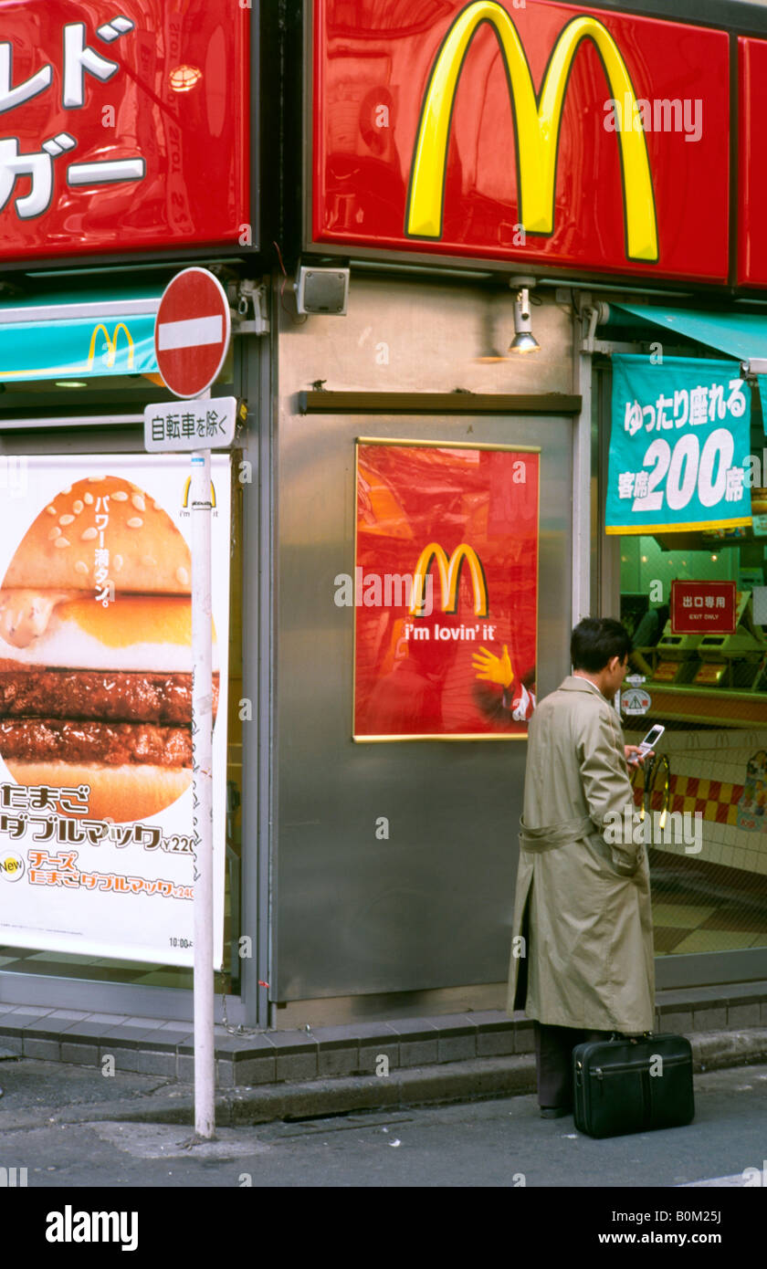 17 févr. 2004 - l'homme avec son téléphone portable en dehors d'une direction générale de McDonald's de Tokyo, Shibuya. Banque D'Images