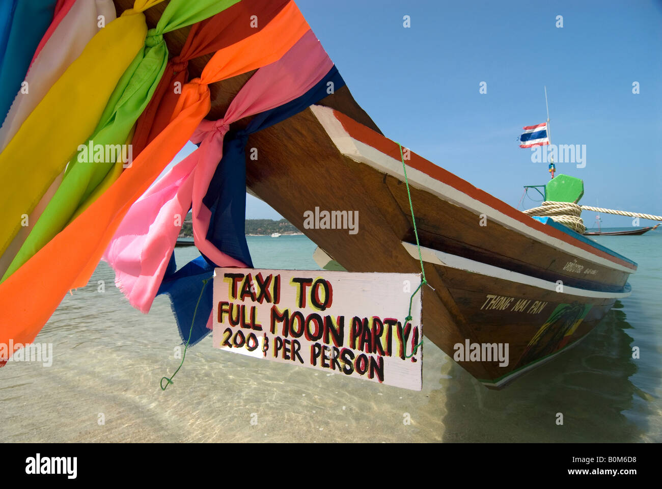 La colorée proue d'un bateau de pêche longtail thaïlandais invite les gens à une full moon party sur une île voisine Banque D'Images
