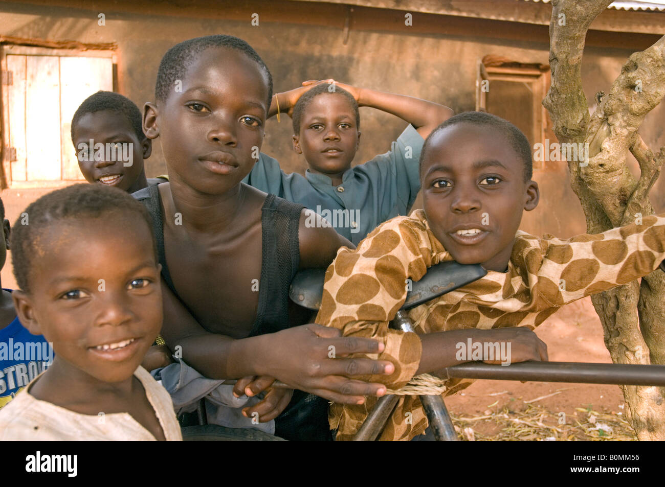 Les enfants curieux s'appuyant sur une bicyclette, Kuluedor, Ghana Banque D'Images