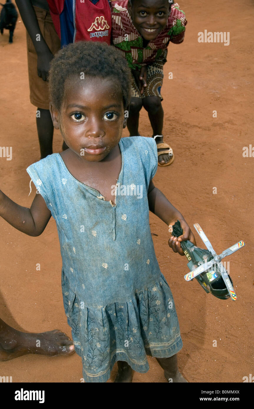 Enfant curieux holding toy hélicoptère, Kuluedor, Ghana Banque D'Images