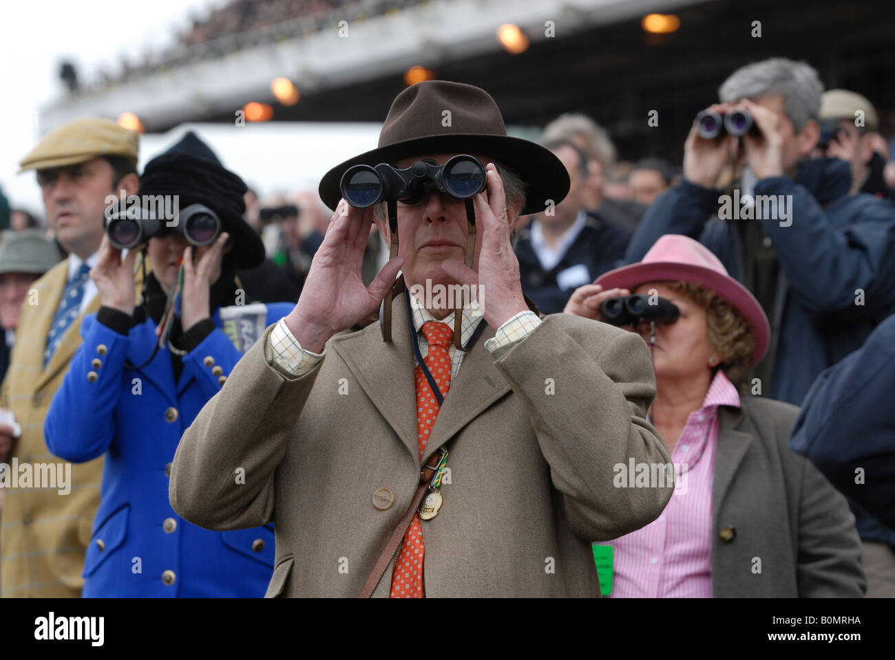 Avec des jumelles Racegoers regarder les courses de chevaux le Cheltenham Festival National Hunt . Banque D'Images
