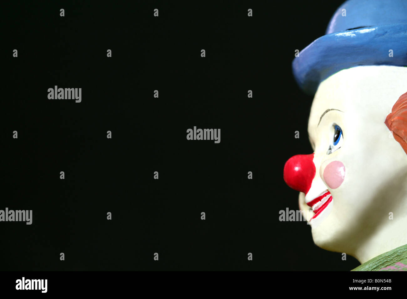 Vue latérale d'un jouet face de clown sur un fond sombre Banque D'Images
