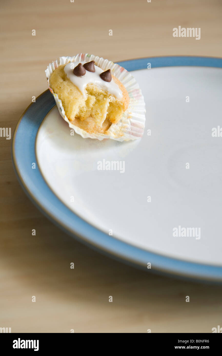 À moitié mangé cupcake disposées sur une plaque bleu et blanc de Chine Banque D'Images