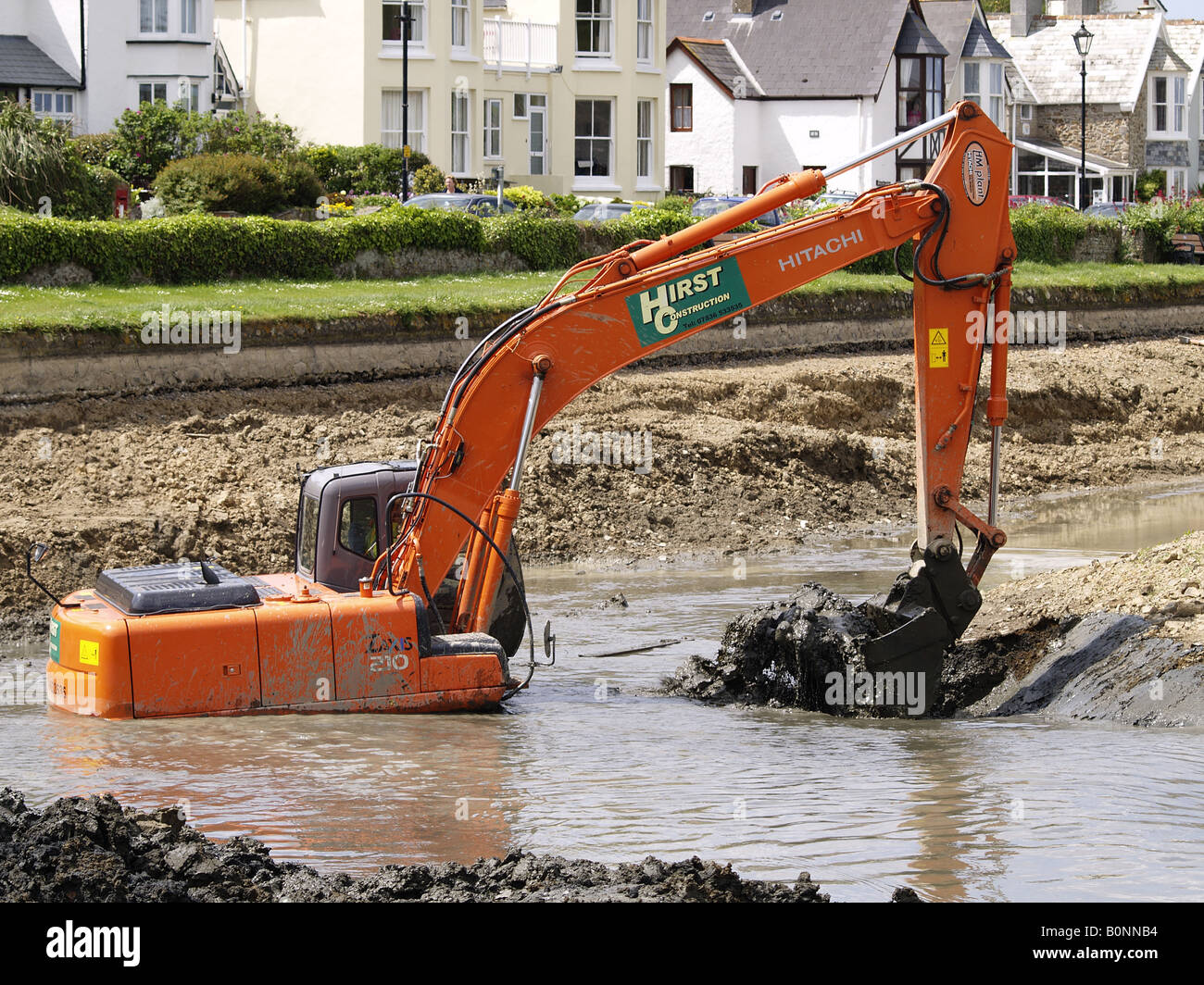 Digger travailler profondément dans la boue et l'eau d'enlever le bas de canal de Bude, Cornwall, UK Banque D'Images