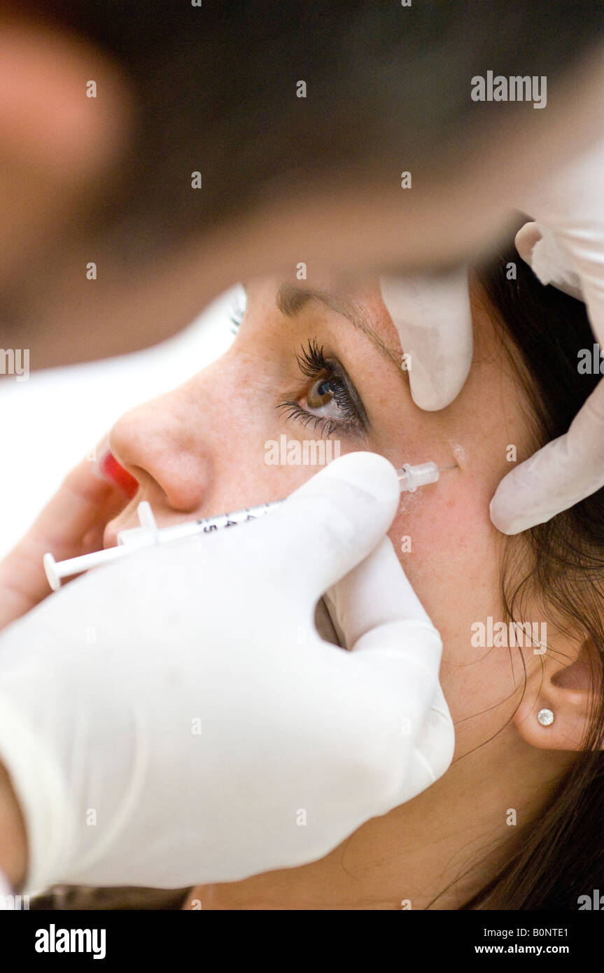 Un médecin administre une réduction des rides Botox injection. Banque D'Images