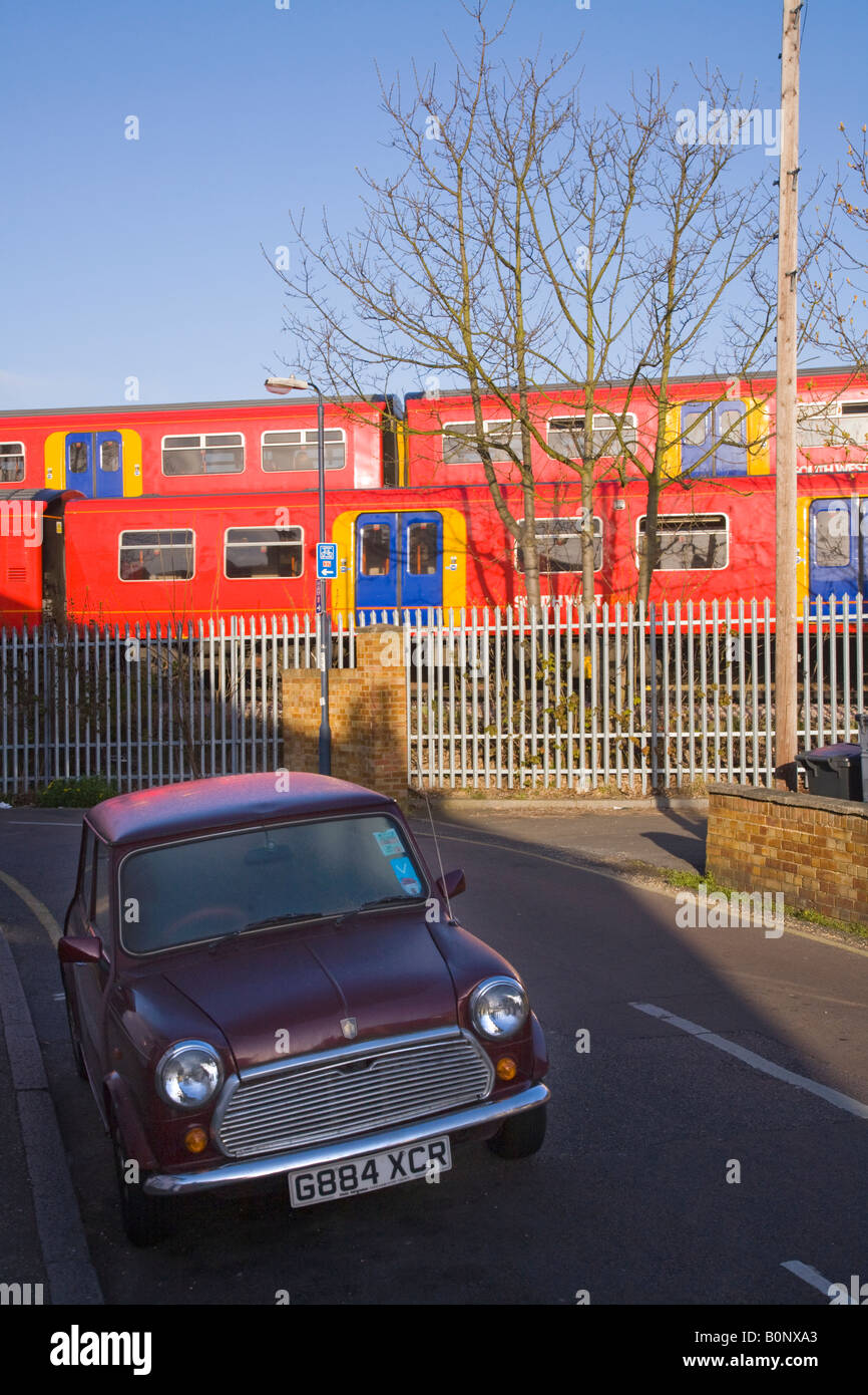 Deux passage des trains passant sur des pistes différentes, et une voiture en stationnement. Twickenham, l'ouest de Londres. UK. Banque D'Images