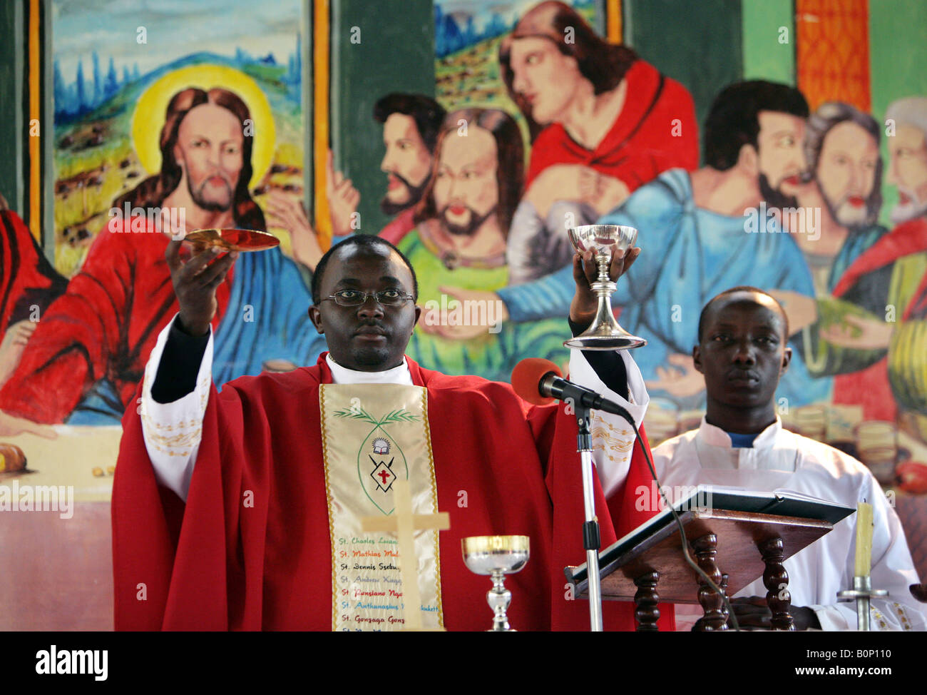 Prêtre catholique holding wine et du pain au cours de l'Eucharistie dans une église de Kikuyu, Kenia Banque D'Images