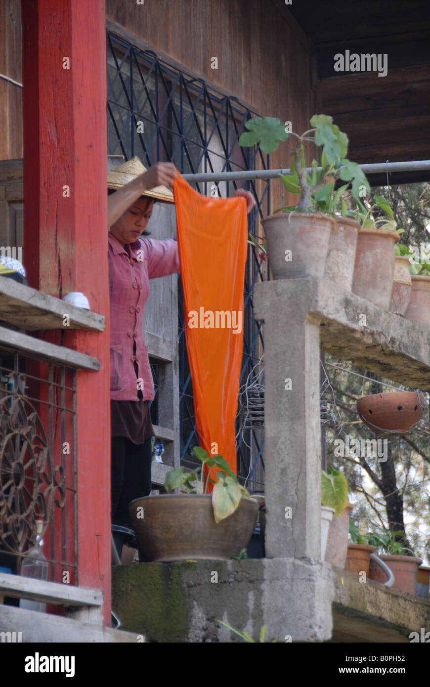 Thai dame robe jaune se lave en temple, Mae Hong Son, Thaïlande Banque D'Images