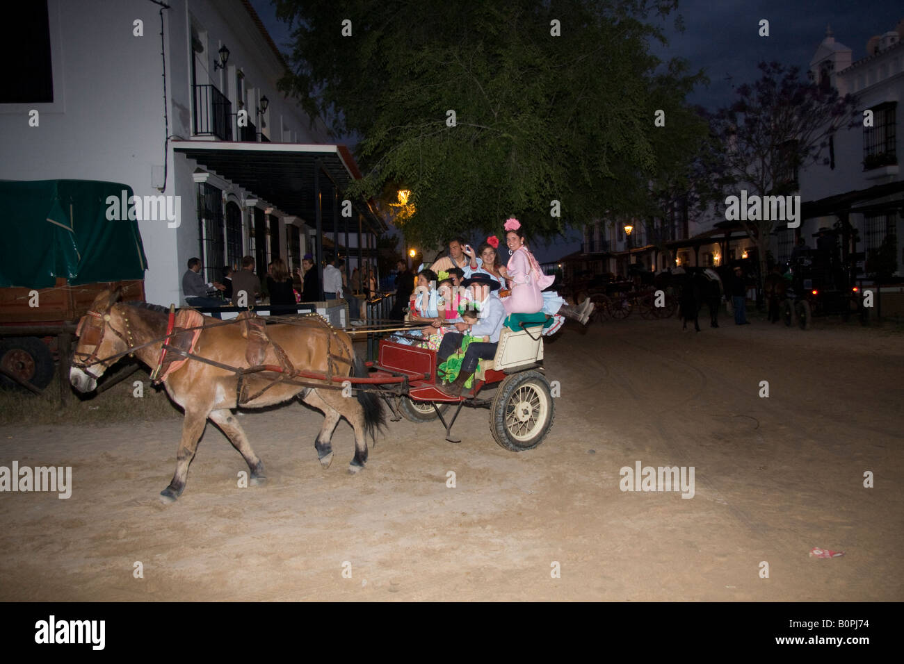 Les amis équitation dans une charrette à travers les rues d'El Rocío Banque D'Images