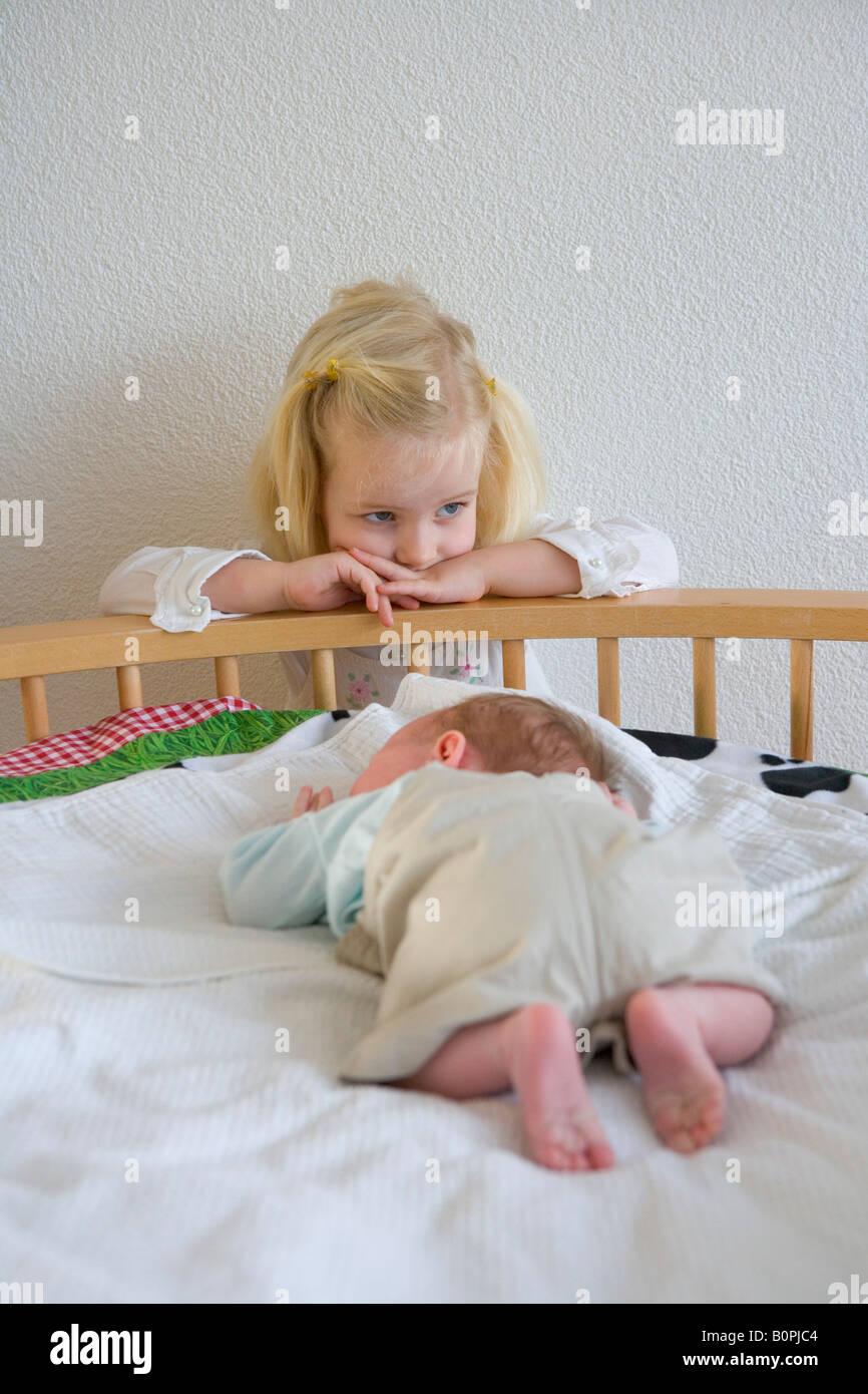 Petite fille est de réfléchir sur le nouveau bébé Banque D'Images