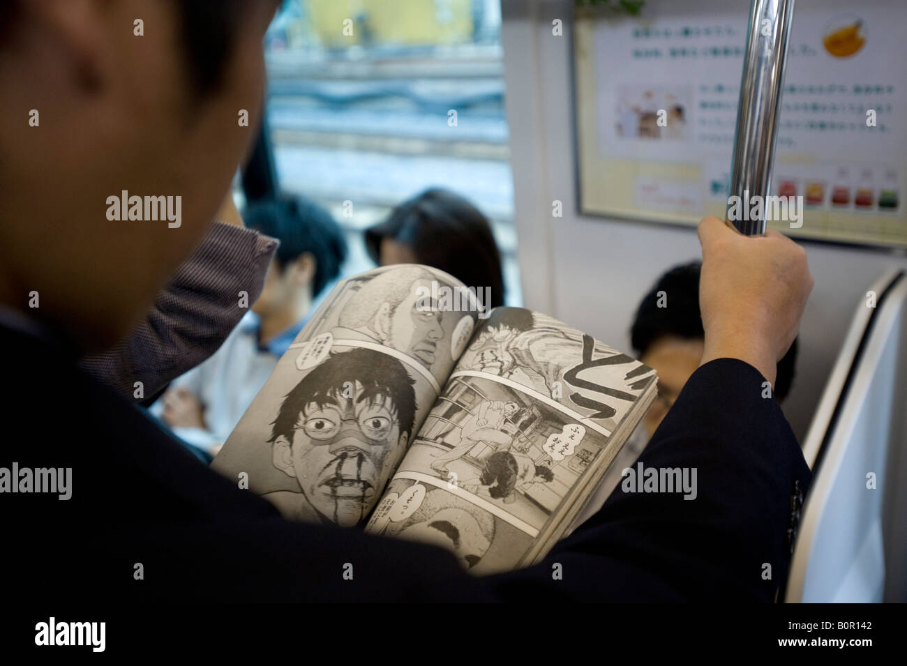 Man reading Manga bande dessinée sur les trains à Tokyo au Japon Banque D'Images