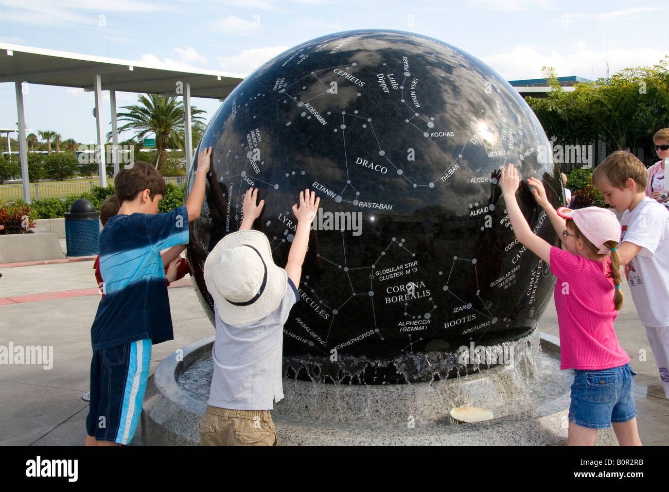 Les enfants pousser la sphère Constellation au Kennedy Space Center Visitor Complex de Cap Canaveral en Floride Banque D'Images