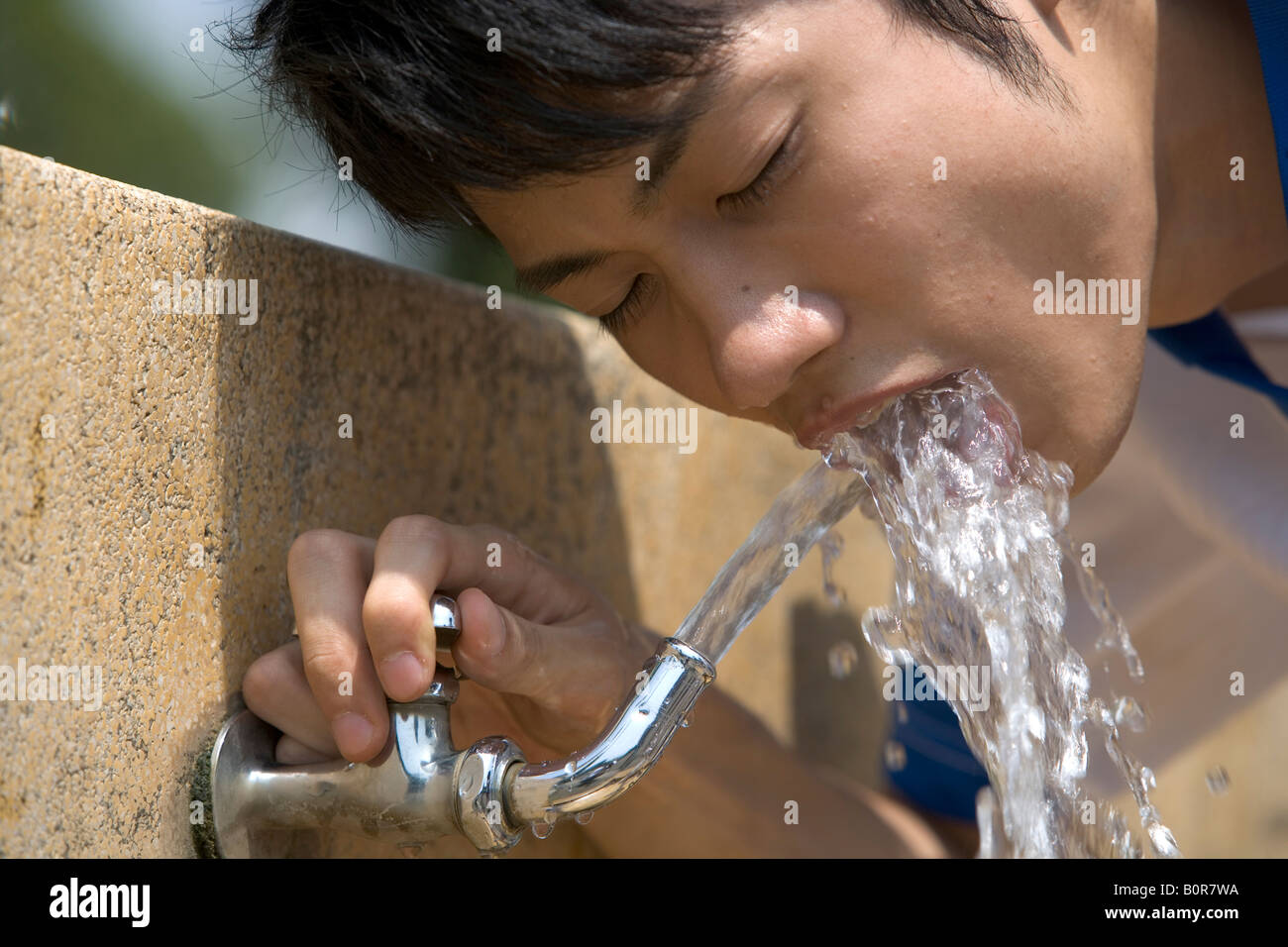 Teenage boy drinking from fontaine d'eau potable Banque D'Images