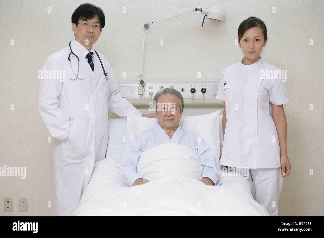 Portrait d'hommes et de femmes médecins au lit du patient Banque D'Images