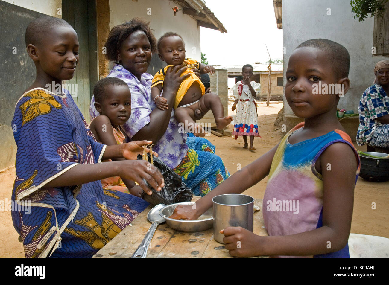 Mère et ses enfants de manger le déjeuner dans l'arrière-cour de leur maison, Kuluedor Ghana Banque D'Images