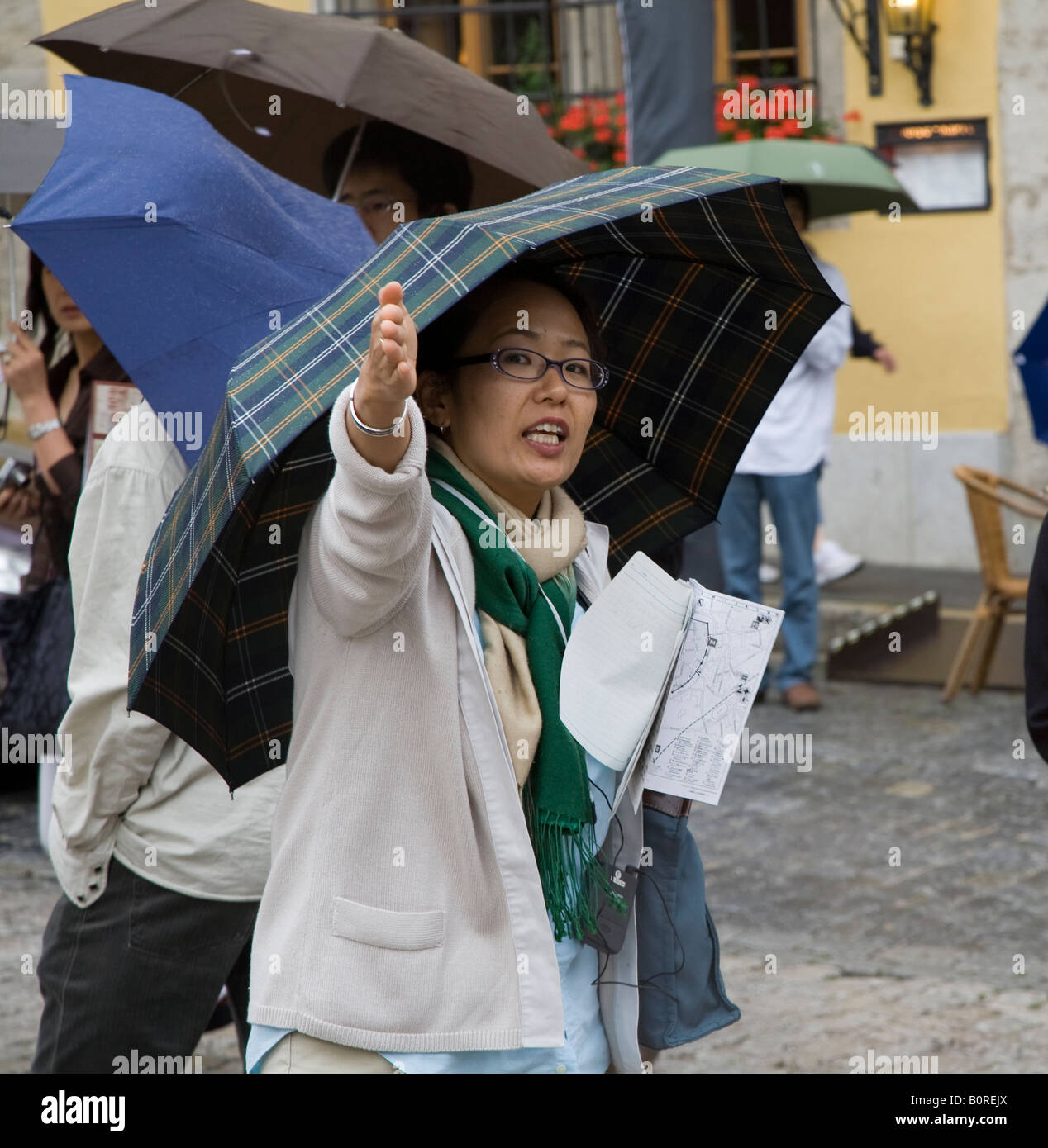 Femme avec parapluie dans la pluie diriger tour group Rothenburg Allemagne Banque D'Images