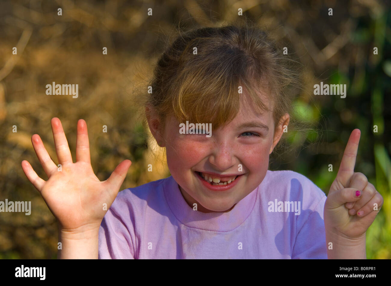 Je m ce beaucoup d'ans six ans girl holding up doigts pour montrer son âge Morro Bay, Californie Banque D'Images