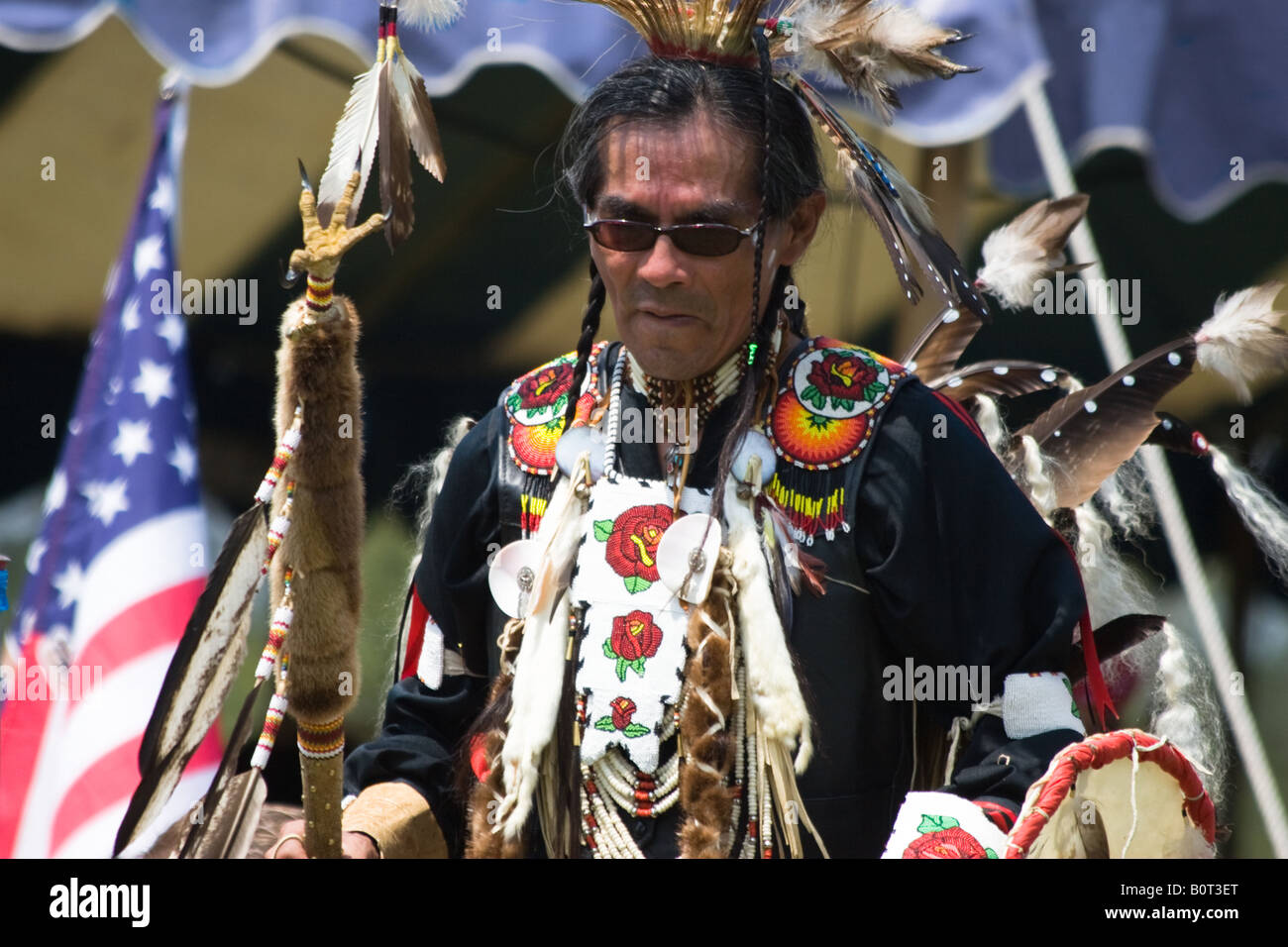 American Indian dancer, drapeau américain en arrière-plan, à la 8e Escadre Rouge Native American pow-wow à Virginia Beach, VA Banque D'Images