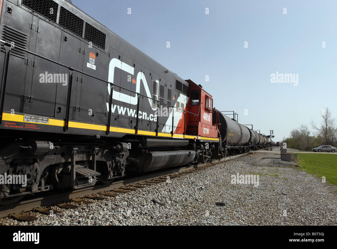 Un train de marchandises du Canadien National traverse un chemin rural dans le midwest des États-Unis près de Chicago. Banque D'Images