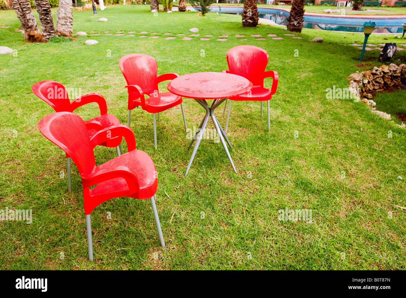 Patio dans en fin d'après-midi à l'extérieur table et 4 chaises rouges Banque D'Images